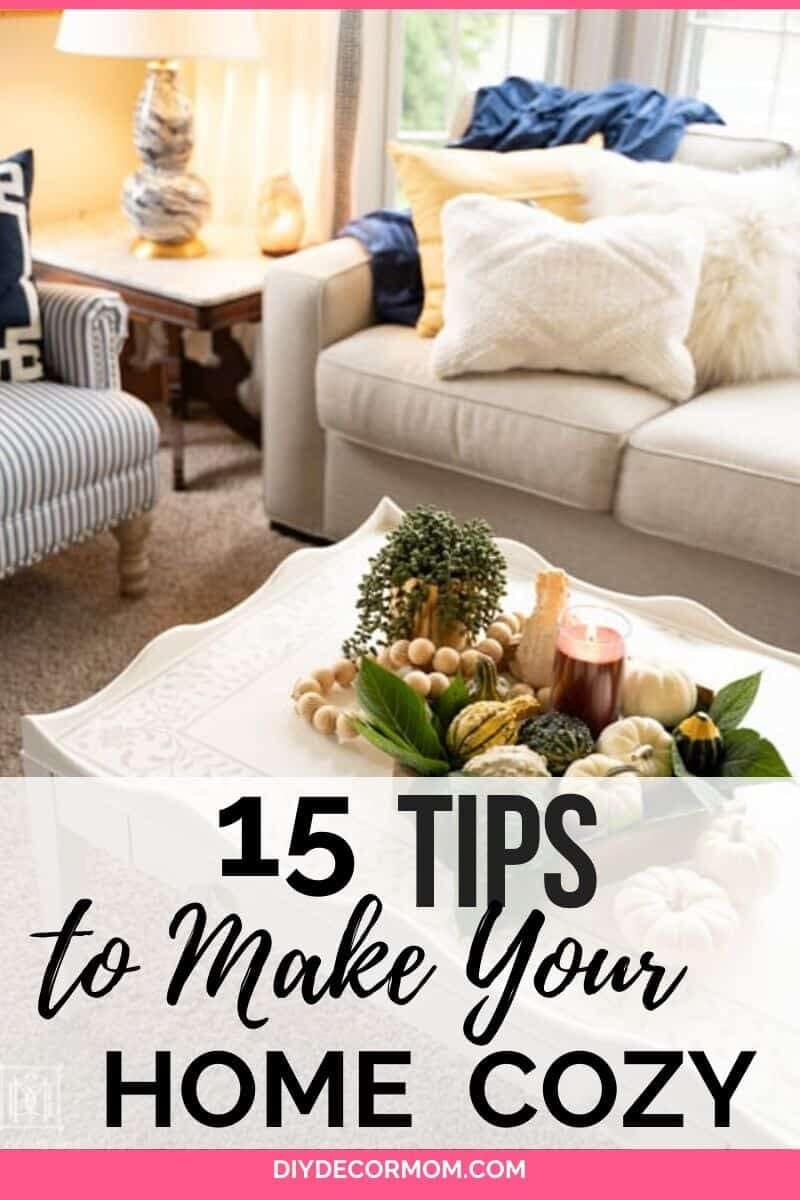 how to make your house cozy--picture of warm cozy vignette in family room with couch, pillows, lighted candles and blankets