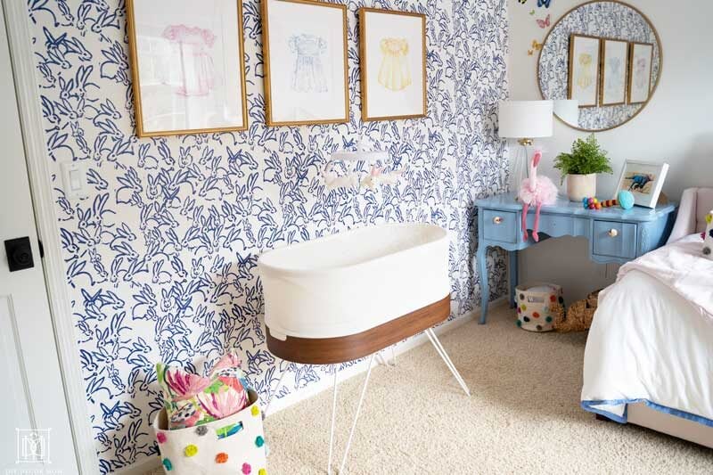 baby girl room decor- snoo in front of bunny wallpaper with blue and white