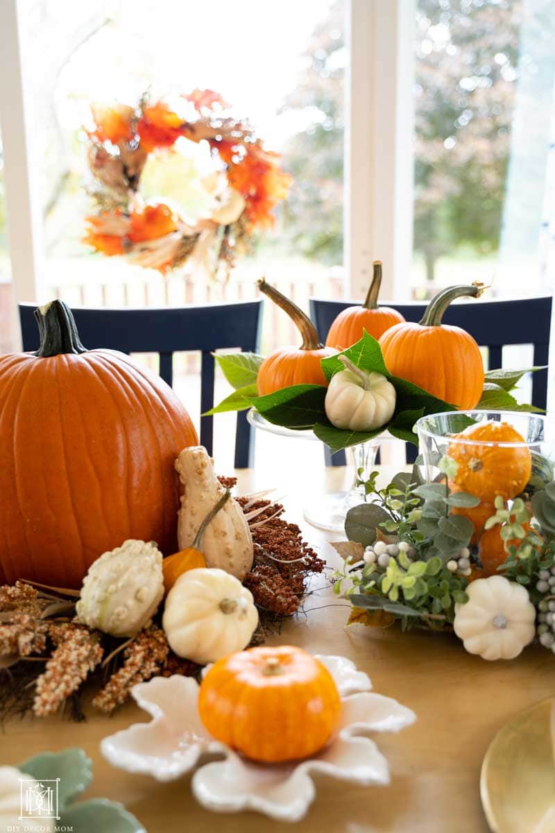 fall wreath over a fall tablescape with pumpkins