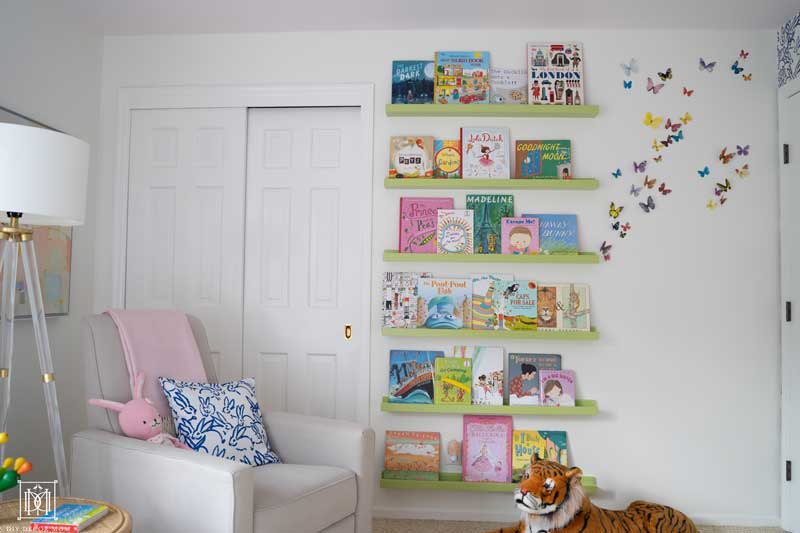 green floating bookshelves book ledge in white nursery with pink ceiling