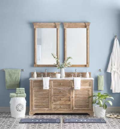 light blue bathroom with wood vanity and double mirror