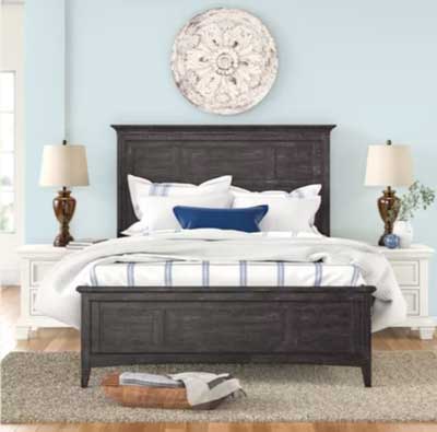 light blue painted bedroom with dark brown wood bed and medallion over the bed