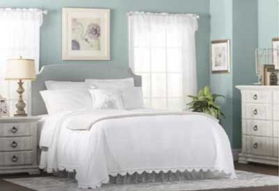 light blue painted bedroom with white bed and sheets