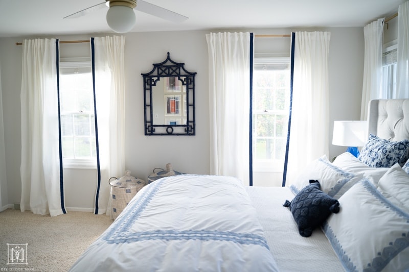 beautiful bedroom with blue and white bedding and white curtains