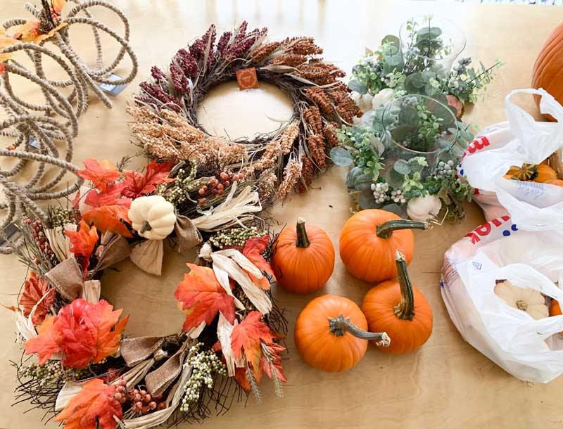 pumpkins and fall wreaths on table