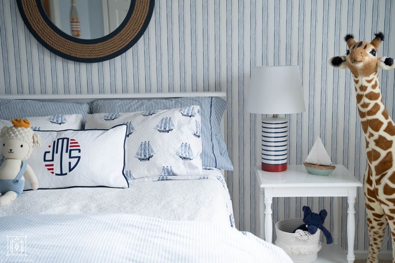 blue and white stripe wallpaper and nautical bedding in boys room