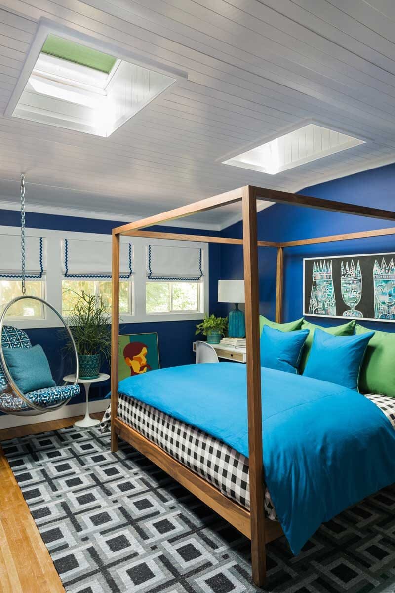 blue guest bedroom with skylights above help improve dark rooms