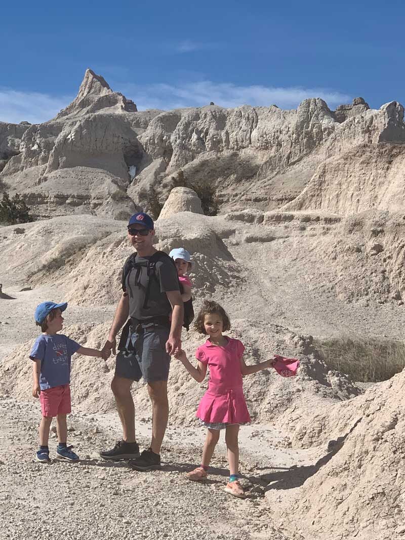 dad with three kids hiking in badlands national park