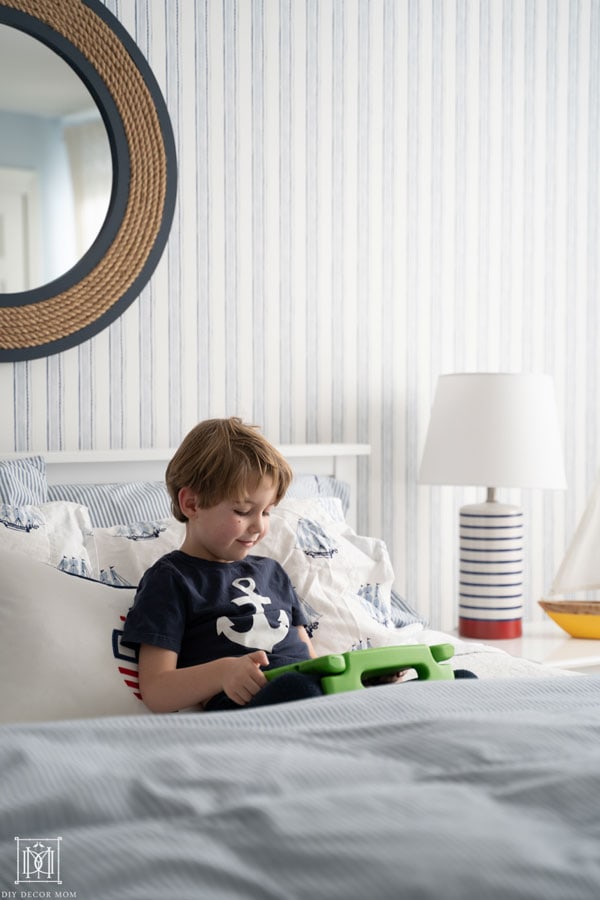 little boy sitting in bed and playing on tablet--see the best parent apps for screentime management