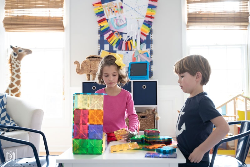 two kids playing building blocks and listening to audiobook in playroom