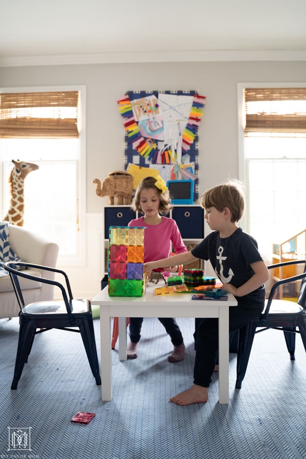 two kids in playroom playing magnatiles