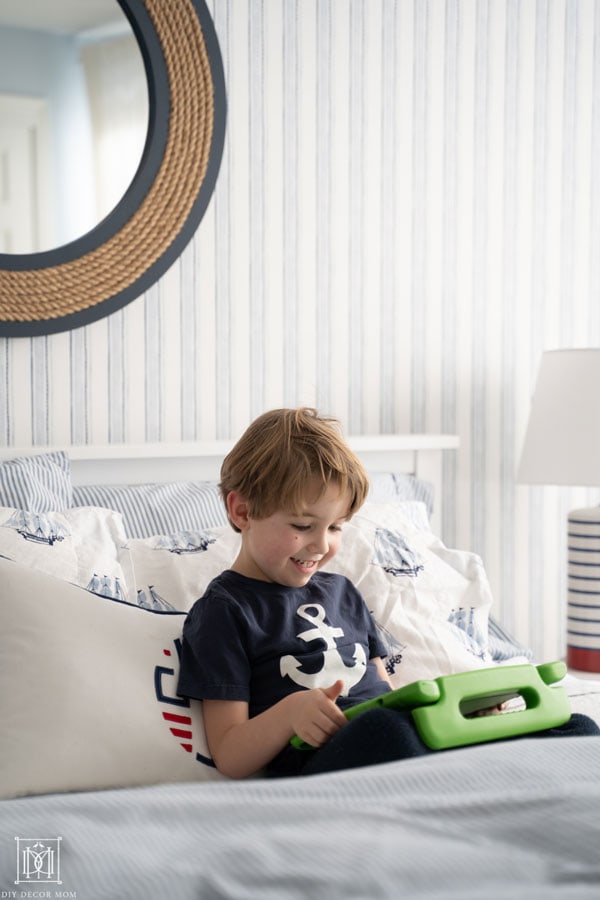 boy playing on ipad in bed