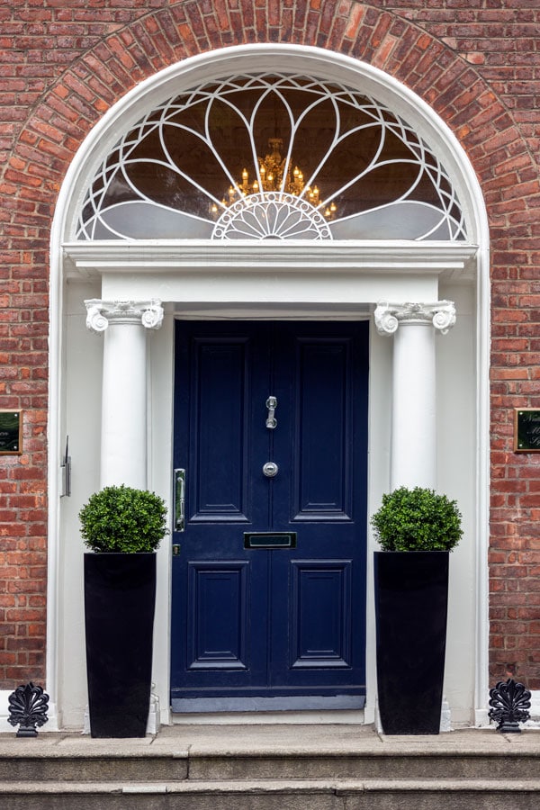 blue front door with brick exterior and two columns