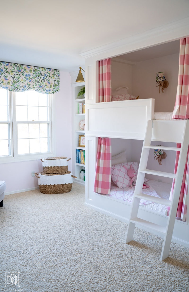 white built-in bunk beds with pink and white bedding and buffalo check curtains and scalloped window valance