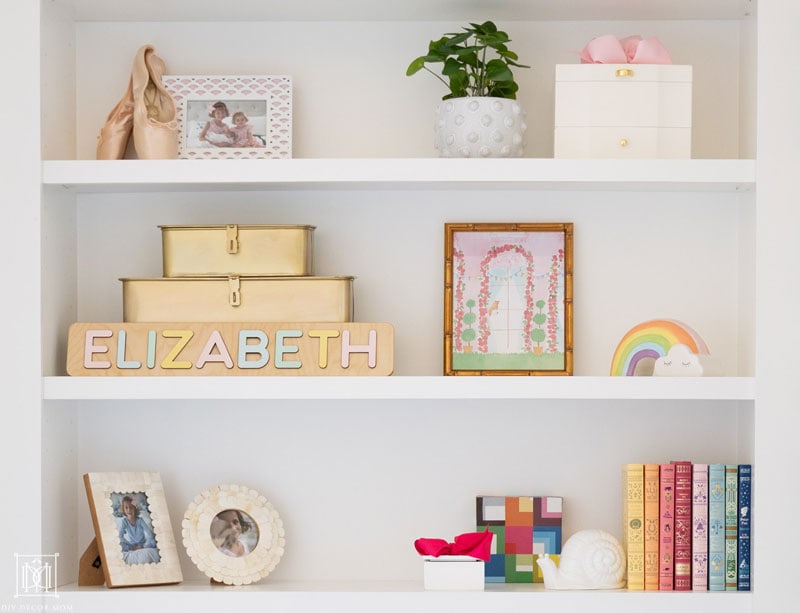 styled girls bedroom bookshelf with decorative objects