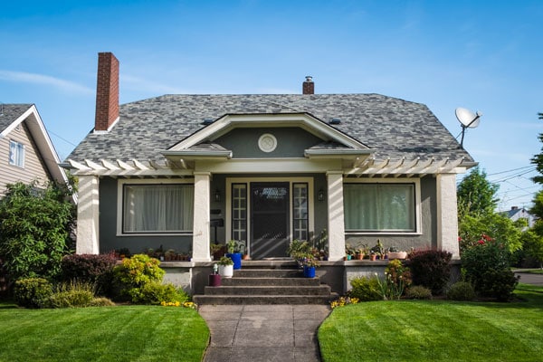 bungalow with sage front door and shingle roof