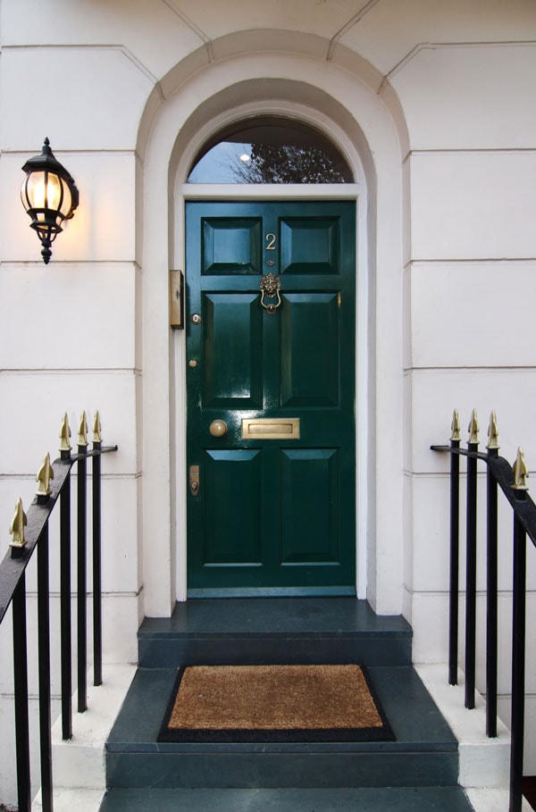 glossy green front door with limestone exterior