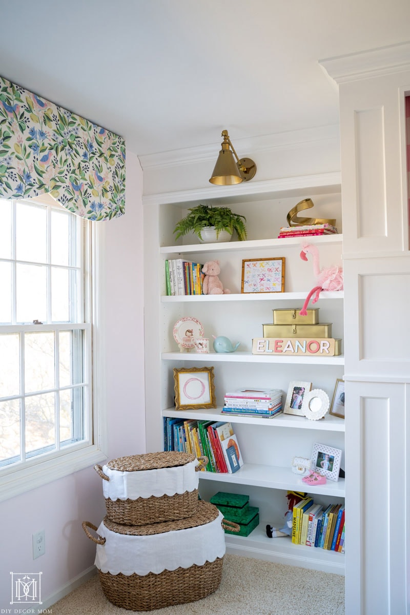 built-in bookcase in girls bedroom with fabric covered window valance and pelmet box