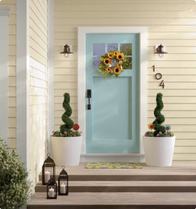 light green aqua front door with planters on either side and lanterns