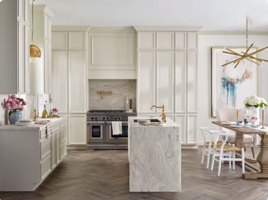 off white kitchen cabinets with waterfall countertop and herringbone floors