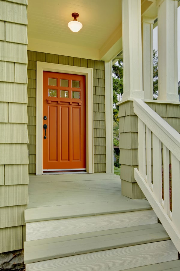 orange front door and green exterior shingles on craftsman house