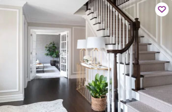 modern console table in white trim stainrway with picture moulding in contrasting paint color