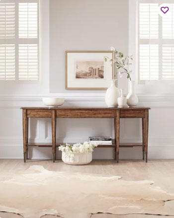 wood table and console in formal room with white trim and wainscoting