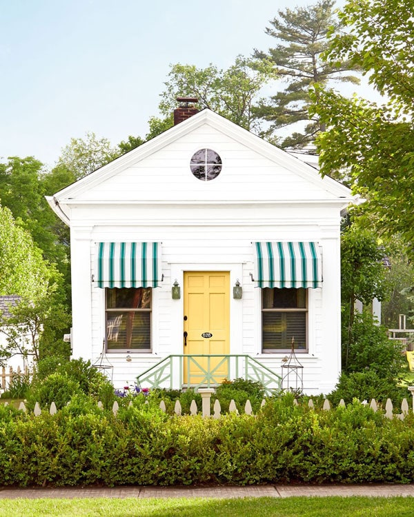 Madcap Cottage's Catskills cottage with a Farrow and Ball's citron bright yellow front door and green and white awnings