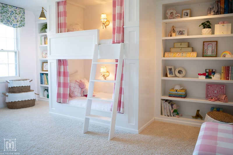 beautiful white built-in bookcases with bunk bed in girls bedroom