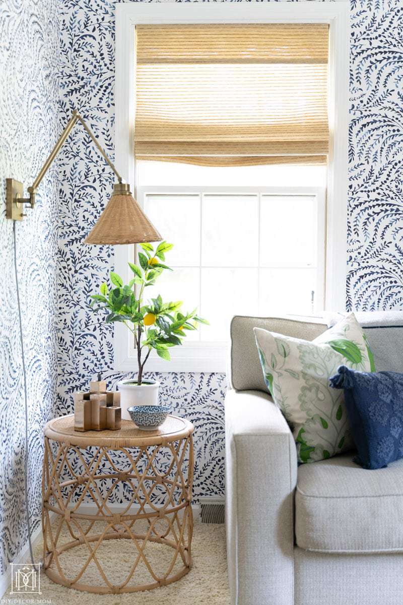 bamboo shades with bamboo table and wicker lamp shade in blue and white wallpapered office/ den