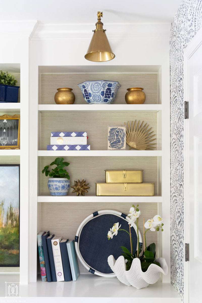 styled bookshelves with faux grasscloth wallpaper