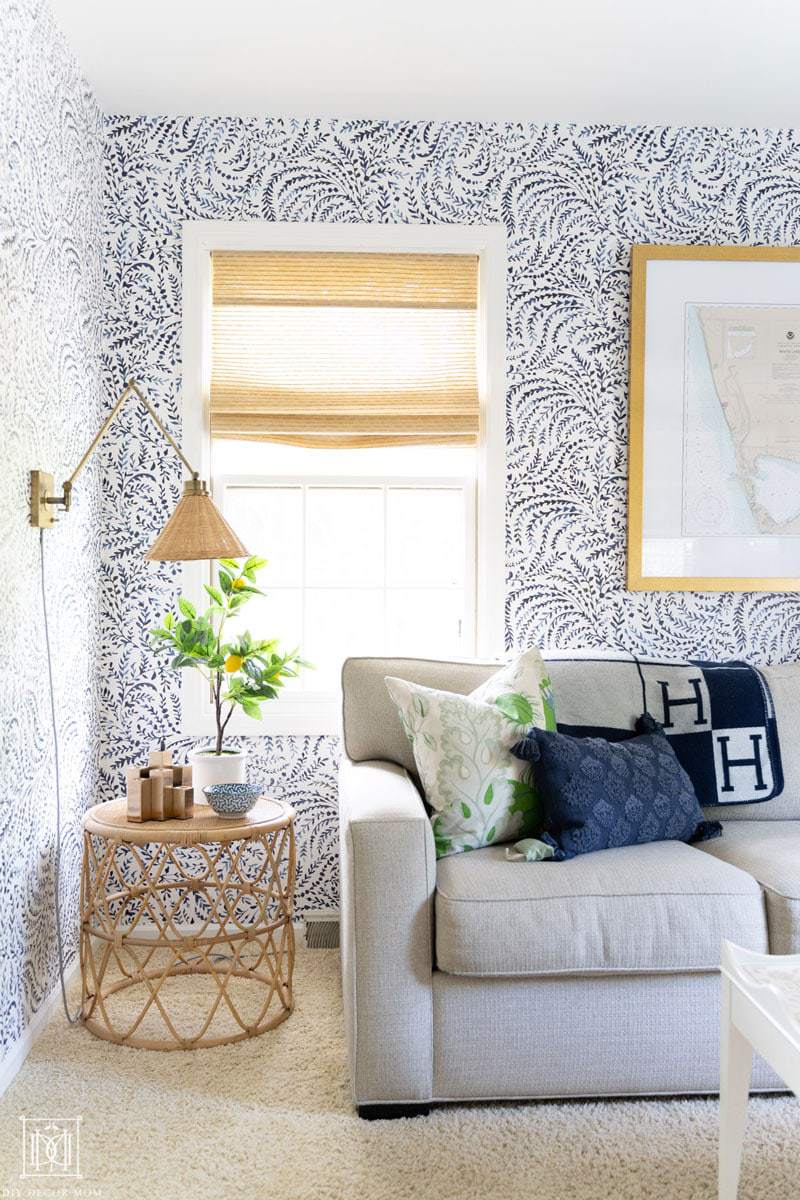 nautical coastal office reveal with bamboo blinds, rattan side table, wicker sconces, and blue and white wallpaper