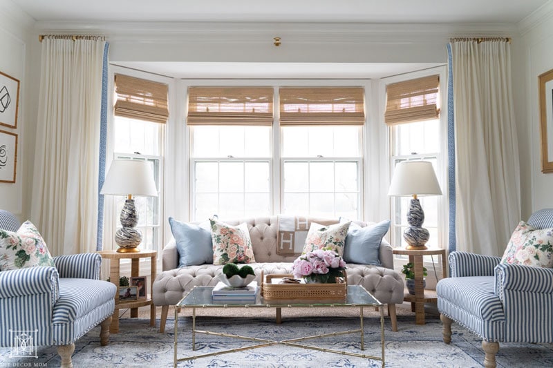 diy lucite curtain rod in living room with chintz pillows on tufted sofa with blue oriental rug