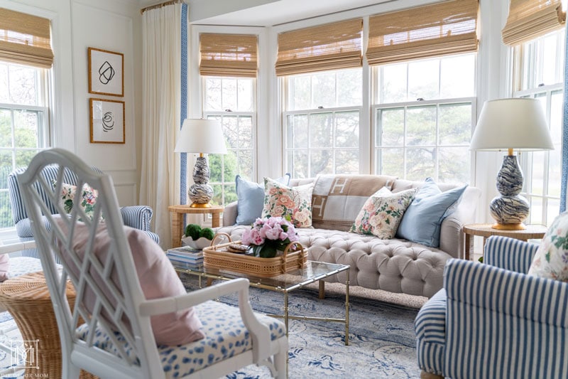 grandmillennial living room with white walls and tufted beige sofa and chintz pillows