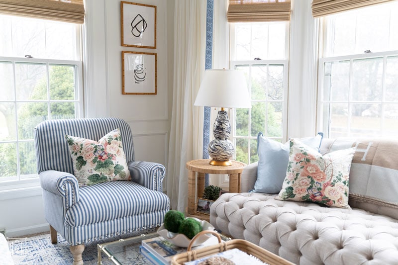 grandmillennial white living room with blue striped chair and chintz pillows