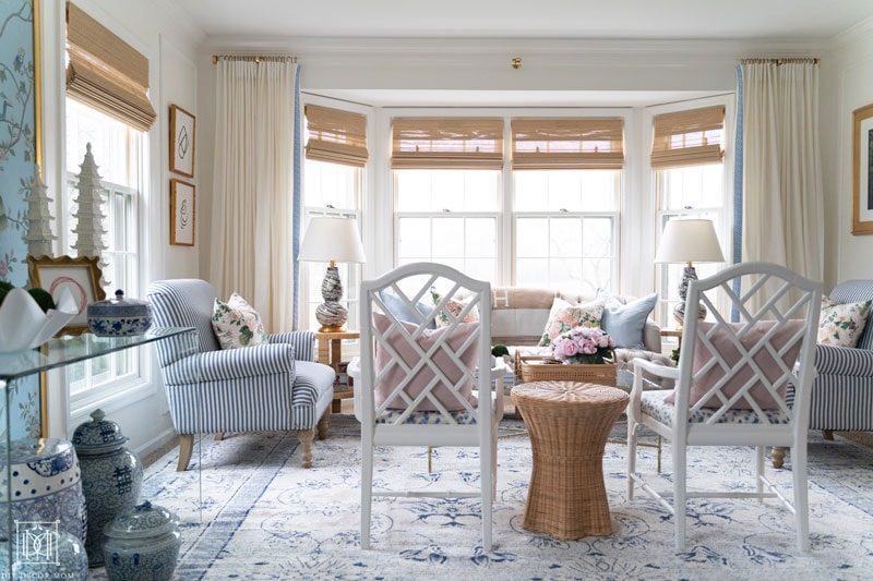 custom lucite curtain rod in living room with chippendale chairs and bamboo shades