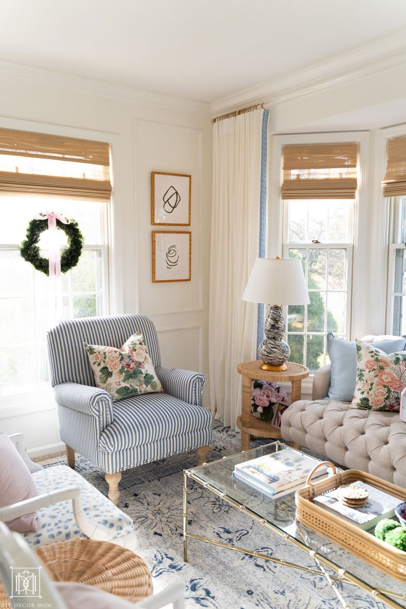 paneled white living room with acrylic curtain rods and bamboo blinds